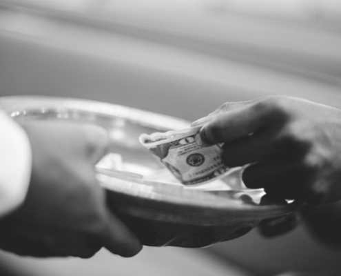A person giving offerings to their church.
