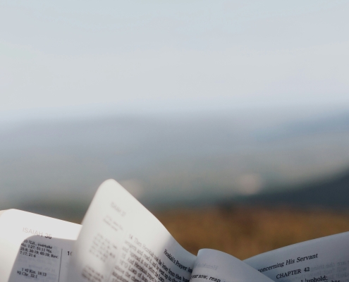 Someone reading a Bible with a mountain view in the background. Being a successful Christian takes hard work.